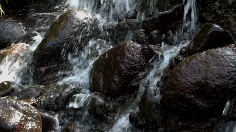Small waterfall with clear water flowing through natural rocks 動画素材 291917954