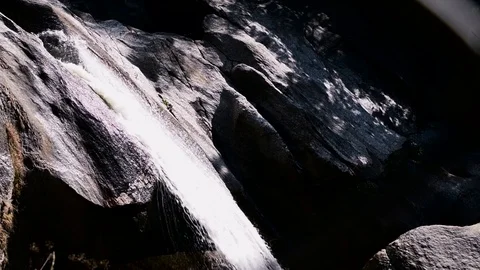 Small waterfall in deep forest, falling from dark stone 库存影片 100543151