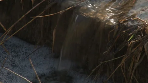 A small waterfall in a ditch that passes through agricultural land, Video stock 154465984