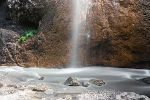 A small waterfall falling on a stone Stock Photos