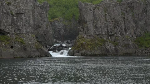 Small waterfall flowing between rocky cliffs in Iceland nature 4K footage Stock Footage 339909805