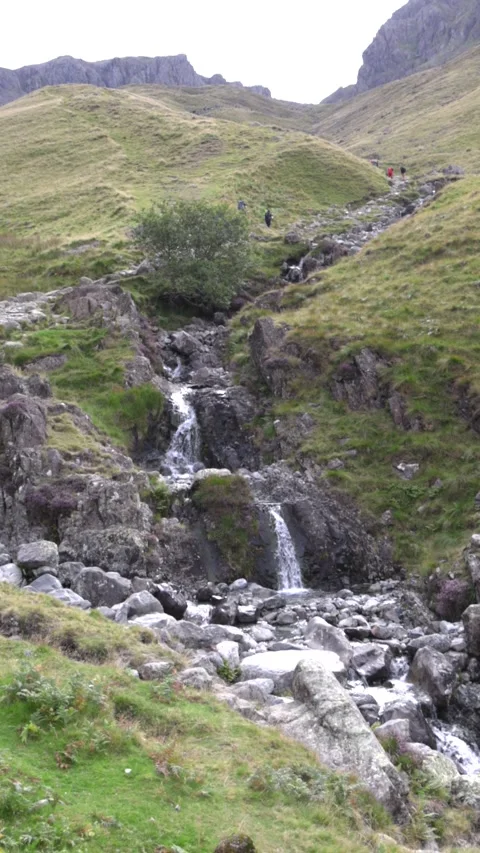 Small waterfall flowing down hiking trail up towards Scafell Pike - Wasdale Stock Footage 343401951