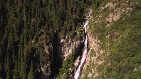 Small waterfall flowing down from mountains in Kyrgyz Republic Stock Footage 300539077