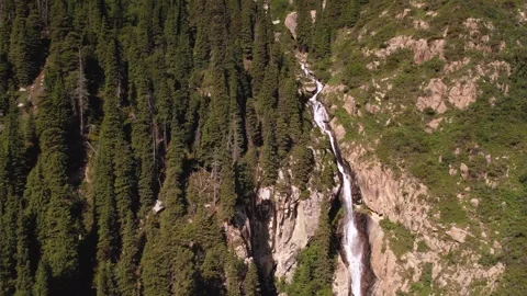 Small waterfall flowing down from mountains in Kyrgyz Republic Stock Footage 300539153