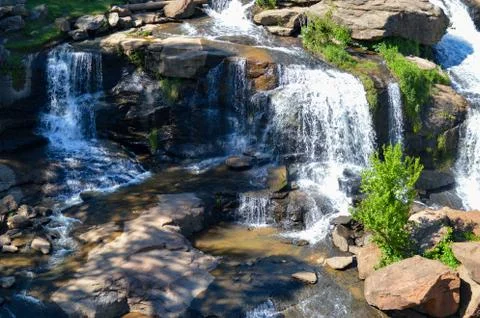 Small waterfall flowing down a rockface in the forest Stock Photos