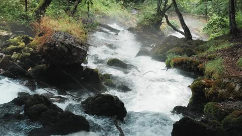 Small Waterfall Flowing Down The Rocks, Mountain River Raging Among The Rocks In Stock Photos