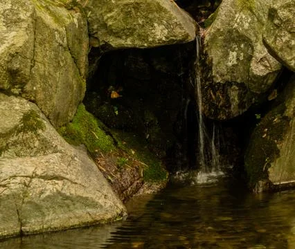Small waterfall flowing over large stones Stock Photos