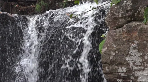 Small waterfall flowing over rocks Stock Footage 61555065