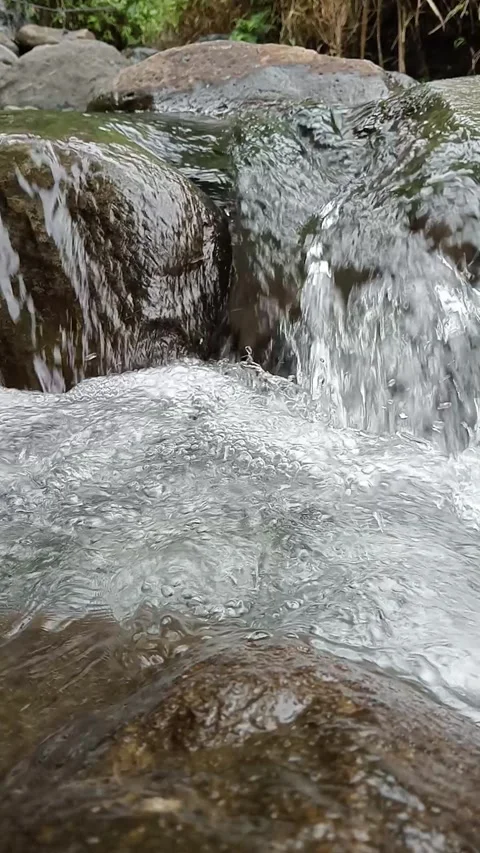 Small Waterfall Flowing Over Rocks in Forest Stock Footage 329892883