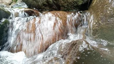 Small Waterfall Flowing Over Rocks in Forest Natural Scene Stock Footage 330581653