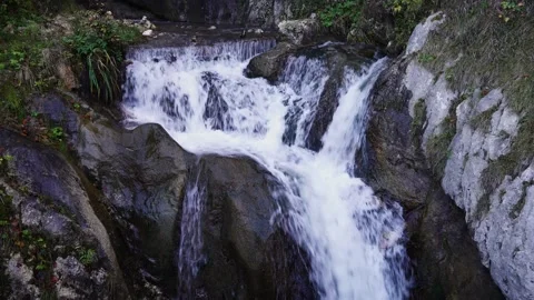 Small Waterfall Flowing Over Rocks and Plants Static Shot Stock Footage 337022528