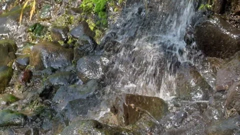 Small waterfall flowing on the rocks of the river cliff Stock Footage 319886624