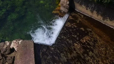 Small Waterfall Flowing from Stone to River in Slow Motion Stock Footage 237997121