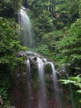A small waterfall that flows between rocks Stock Photos