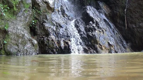 A small waterfall flows over a small lake in the city of Jijel Stock Footage