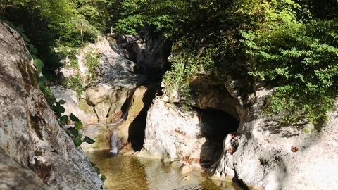 A small waterfall flows into a pond located in the rock. Stock Footage 106853675
