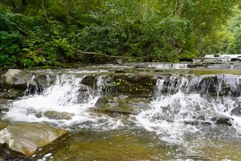Small waterfall in forest river at Bykovsky Rapids, Sakhalin. Stock Photos