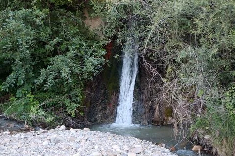 A small waterfall joins the river Stock Photos