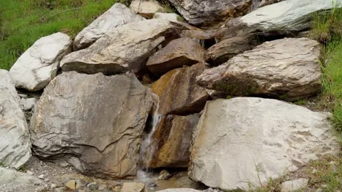 Small waterfall makes its way through the rocks Stock Footage 283564904