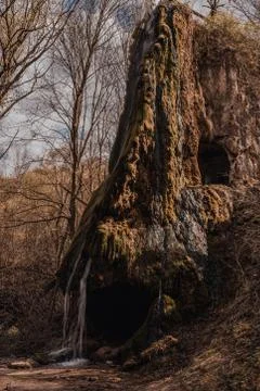 A small waterfall on a mountain overgrown with moss Stock Photos