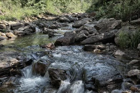 Small waterfall of mountain river in summer Stock Photos