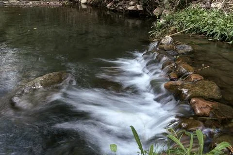 A small waterfall in a mountain stream Stock Photos