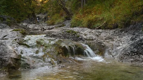 A small waterfall from a mountain stream un autumn mood Video stock 260862361