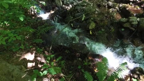 A small waterfall in the mountains. Mountain river in the gorge. Walk through Stock Footage 166067806