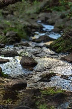 Small waterfall or cascade captured near the water surface full of rocks and  Stock Photos