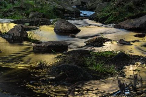 Small waterfall or cascade captured near the water surface full of rocks and  Stock Photos
