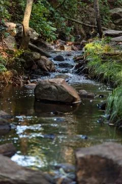 Small waterfall or cascade captured near the water surface full of rocks and  Stock Photos
