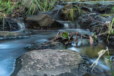Small waterfall or cascade captured near the water surface full of rocks and  Stock Photos