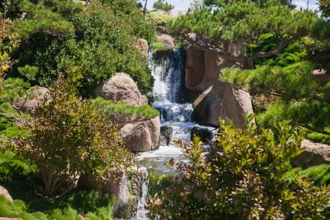 Small waterfall in the park at summer time Stock Photos