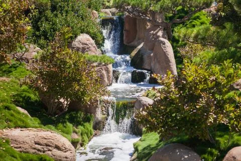 Small waterfall in the park at summer time Stock Photos
