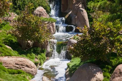 Small waterfall in the park at summer time Stock Photos