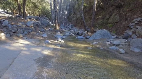 Small waterfall pouring down to a creek Stock Footage 73436936
