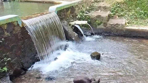 A Small Waterfall With PVC Pipes Channeling Water Into A Shallow Stream Stock Footage 339317543