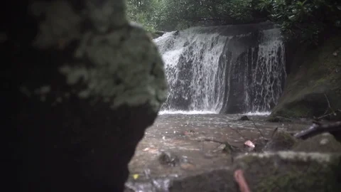 Small waterfall in the rain mountain southeast handheld 1 Stock Footage 76716483