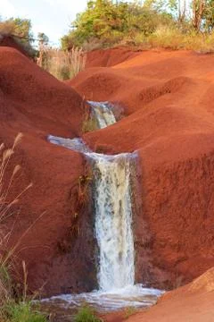 Small waterfall on red soil Stock Photos
