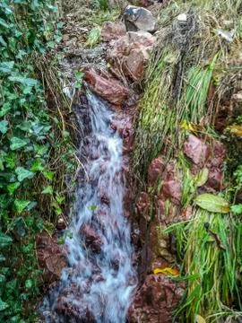 Small waterfall with reddish rocks Stock Photos