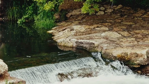A small waterfall on the river against a green forest. slow motion Stock Footage 108627010