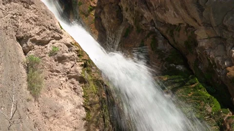Small waterfall with roaring stream of flowing water between rocks, covered with Stock Footage 202233478