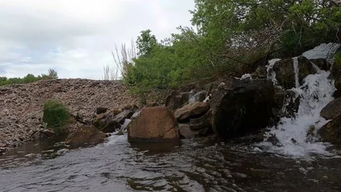 Small waterfall on the  rocky beach Stock Footage 168837752