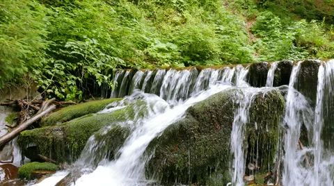 Small waterfall   with stone in moss in summer day close up . 4K 3840x2160.  Stockbeeldmateriaal 53240534
