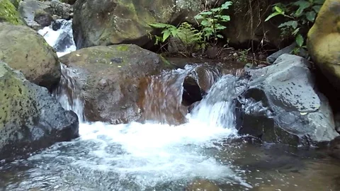 Small waterfall stream among big black rocks on the river on mountain Stock Footage 124682863