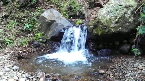 Small waterfall stream between big blcak rocks on the small river Stock Footage 124776547