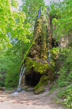 Small waterfall on stream flowing along the rock with grottoes Stock-Fotos