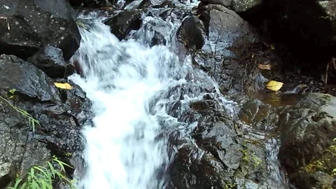 Small waterfall stream on small river on mountain on black rock Stock Footage 124950314