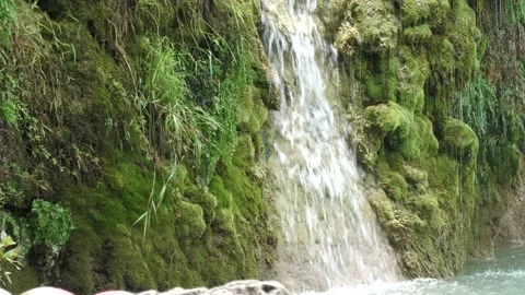 Small waterfall with tiny rivulets of water falling on the mossy sides  Video stock 168185290