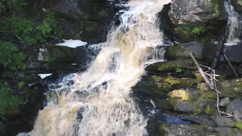 A small waterfall, water flows violently along rocky ledges Video stock 161824583